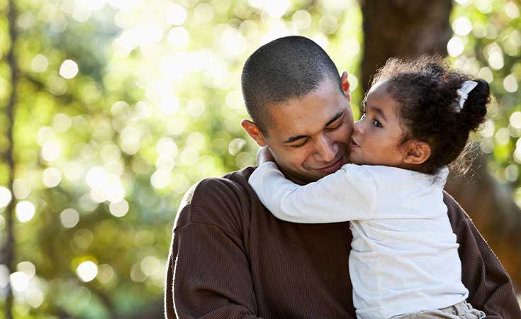 father holding and hugging his young daugther