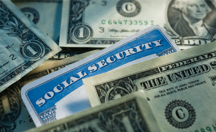 a social security card in a pile of dollar bills